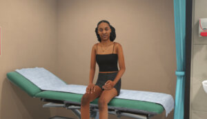 Young Woman Sat on GP Bed